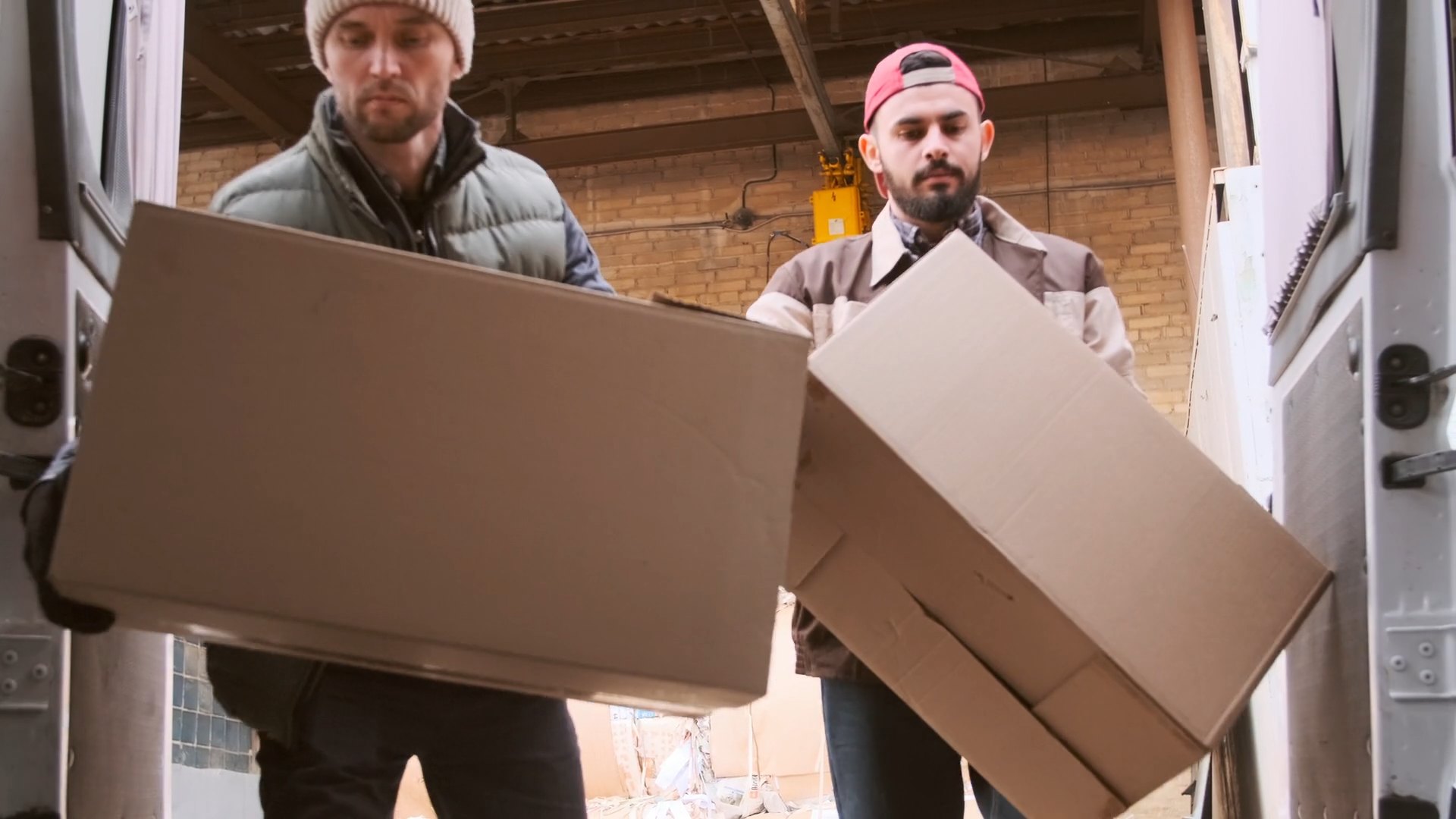 Workers load boxes into a delivery van